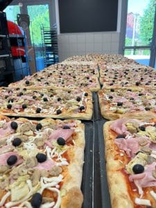 Distribuição de pizza durante a noite beneficente no L Orto del Molino